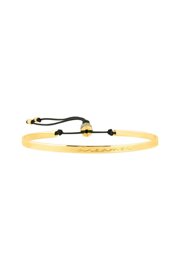 Gold bracelet with black cord on a white background