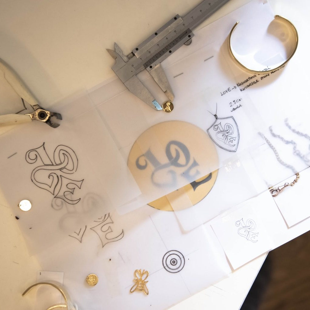 Jewelry items including necklaces and earrings on a white surface with measurement tools.